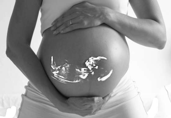 pregnant woman's belly with image of fetus